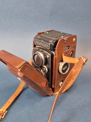 un appareil photo marron muni d'une lanière en cuir
