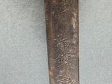 a knife with a yellow handle hanging on a wall