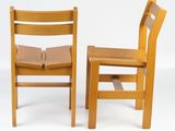 two wooden chairs that are sitting next to each other