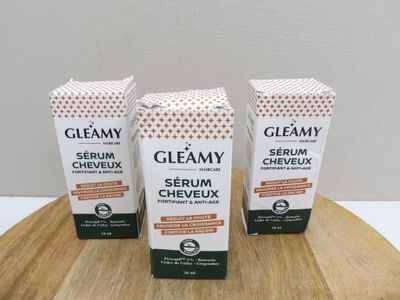 three bottles of glamy serum on a wooden table