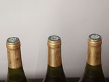 three bottles of wine are lined up in a row on a table