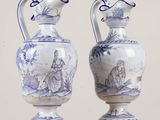 une paire de vases bleus et blancs ornés de personnages, posés sur une table