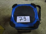 une valise bleue avec un autocollant, posée par terre