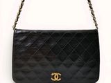 un sac à bandoulière Chanel en cuir noir avec des finitions dorées