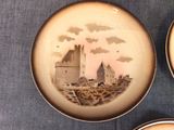 two plates with a picture of a castle on them sitting on a table