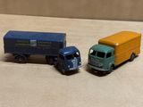 deux camions jouets assis l'un à côté de l'autre sur une table