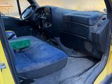 a yellow truck with a blue seat in the back of it