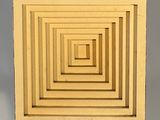 un petit objet de forme carrée posé sur un socle et projetant une ombre