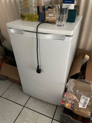 a white refrigerator with a bottle of water on top of it