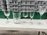 several empty wine glasses sitting on a table in a warehouse