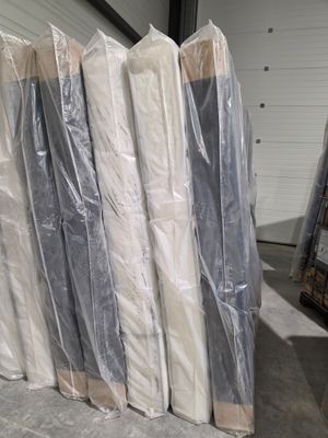 de nombreux matelas emballés dans du plastique dans un entrepôt