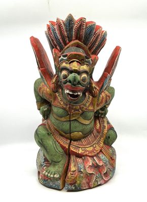 statue d'un démon verte et rouge tenant un couteau