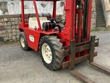 a red fork lift truck parked in front of a building