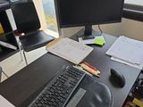 un bureau sur lequel se trouvent un clavier, un écran, une souris et d'autres objets