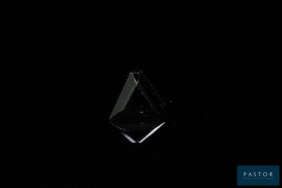 a close up of a black diamond on a black background
