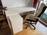 a white desk with a black chair in front of a window