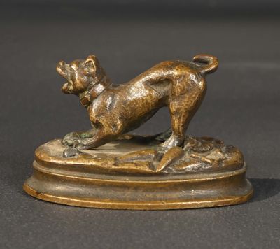 statue en bronze représentant un chien, posée sur un socle, sur une surface noire