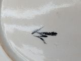 a white plate with a bird on it on a table