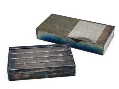 Deux boîtes métalliques, de couleurs et de motifs différents, sont posées sur une surface blanche.
