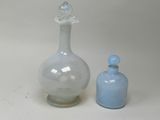 two glass bottles sitting next to each other on a table