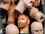 de nombreuses têtes de mannequins dans une boîte, dont une représentant le visage d'un homme