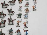 many figurines of people riding horses and horses