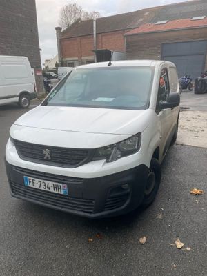 une camionnette blanche garée sur le bord de la route, devant un immeuble