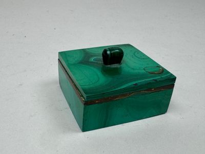 une boîte verte contenant une pomme noire