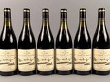 six bouteilles de vin sont alignées dans une rangée