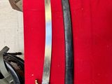 two swords that are on display on a red cloth