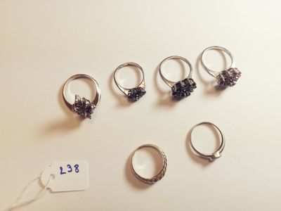 six different rings are arranged on a table with a price tag