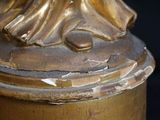 a statue of a woman holding a bird on top of a table