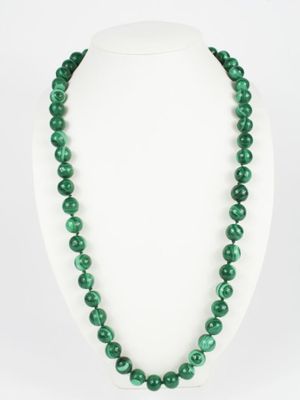 un collier de perles vertes sur un mannequin blanc