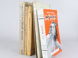 trois livres sont empilés sur une surface blanche