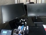 un bureau sur lequel se trouvent deux écrans et un téléphone