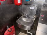 a sink and a fire extinguisher in a public restroom