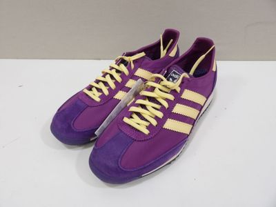 a pair of purple and yellow sneakers with yellow laces