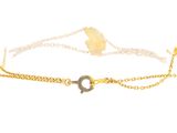 a close up of a gold chain bracelet with a circle on it