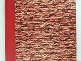 a close up of a book with a red cover on a white surface