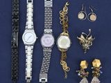 a lot of jewelry that is laying out on a blue surface