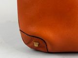 a brown leather handbag with gold hardware on the handle