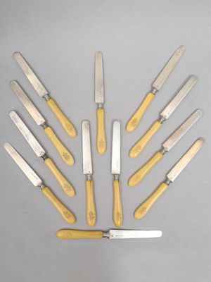 six couteaux à manche jaune sont disposés en cercle sur une surface grise