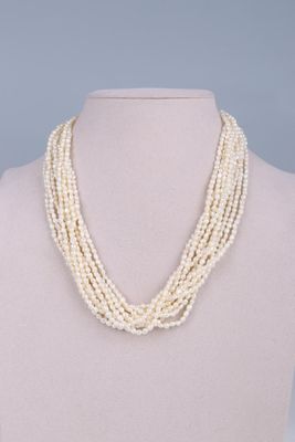 a close up of a white necklace on a mannequin mannequin