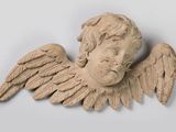 une statue représentant un ange ailé posée sur un socle blanc