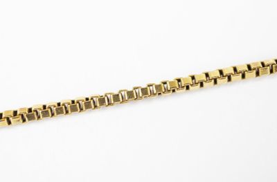 a close up of a gold chain on a white surface
