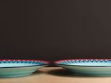 pair of blue and red bowls sitting on top of a wooden table