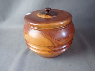 une petite boîte en bois avec un couvercle, posée sur une table