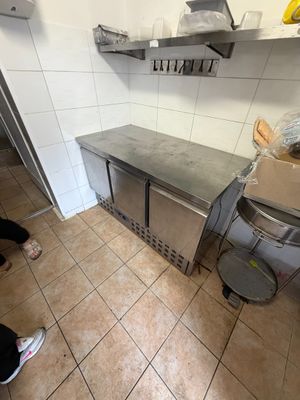 une femme debout dans une cuisine, près d'un plan de travail