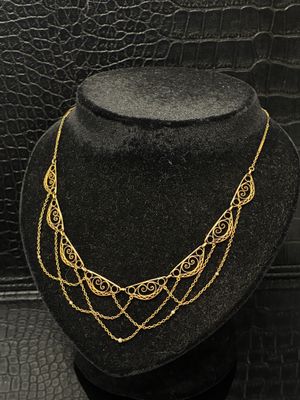 un mannequin noir avec un collier en or et un chapeau noir