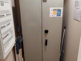 un réfrigérateur dans un coin de la pièce, avec une télévision accrochée au mur